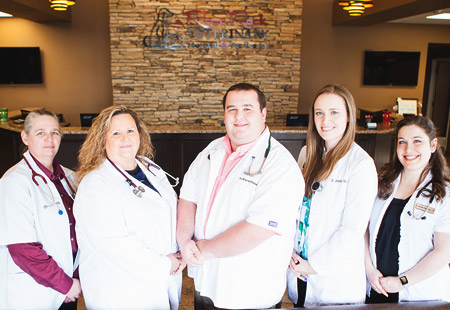The five veterinarians of Rose Rock Veterinary Hospital & Pet Resort wearing white scrubs over their clothes in Norman, OK.